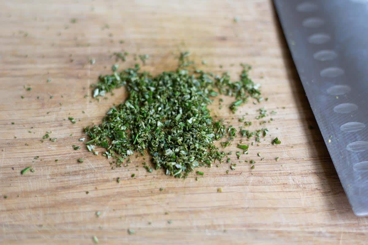 finely chopped fresh parsley on a chopping board beside a sharp knife