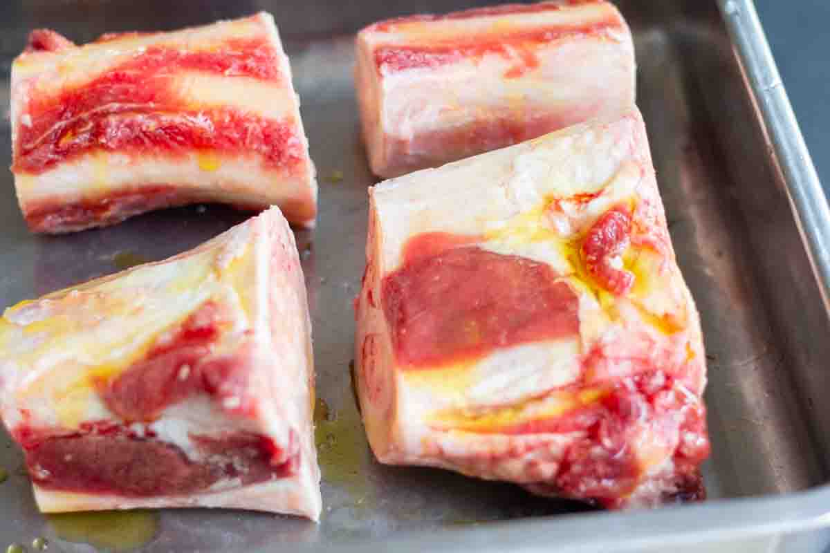 beef marrow bones drizzled in oil on a bakig tray