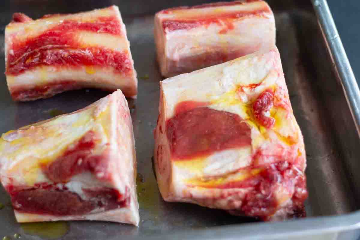 beef marrow bones drizzled in oil on a baking sheet