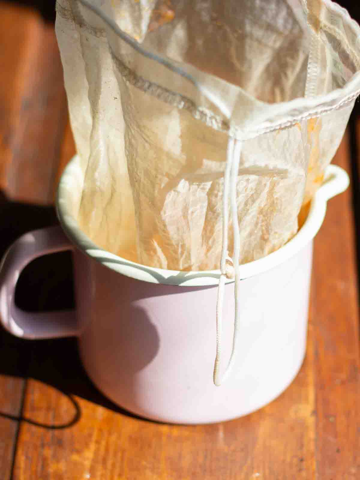 a jelly strainer in a small pot