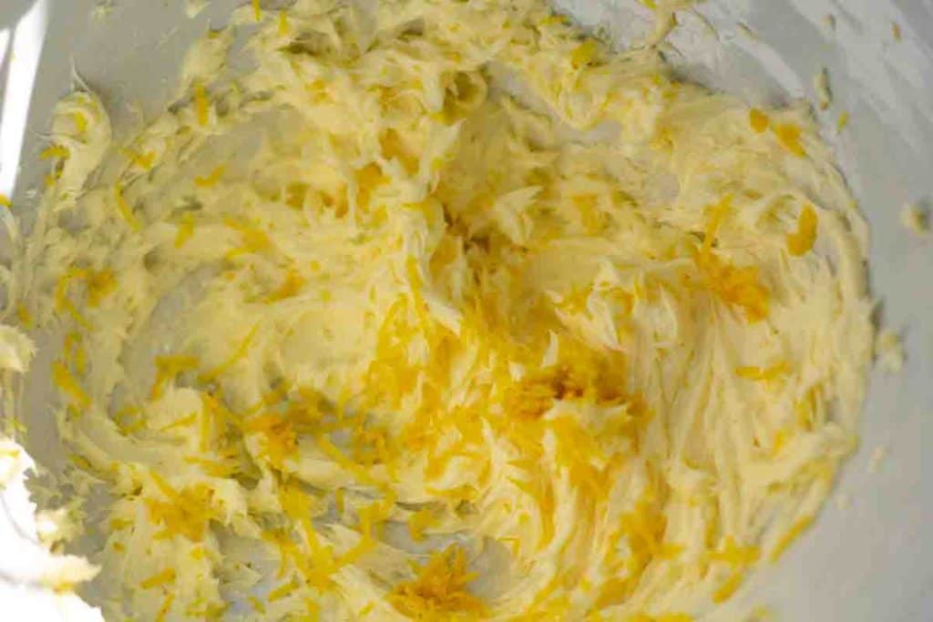 lemon zest added to a bowl of whipped butter