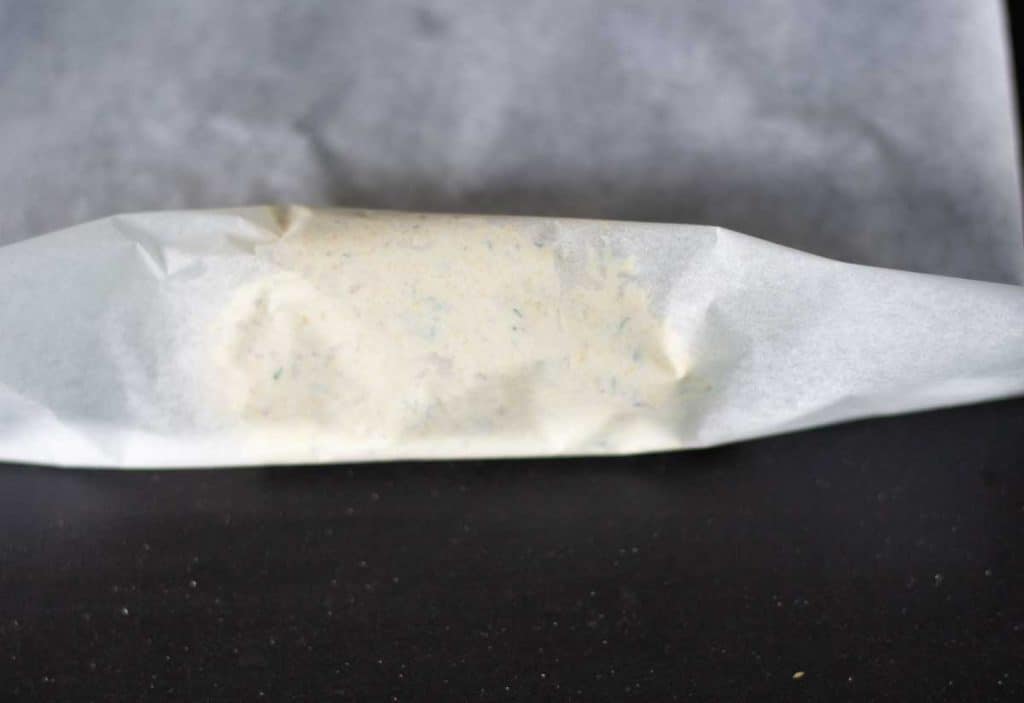 butter in parchment paper being rolled to a log shape