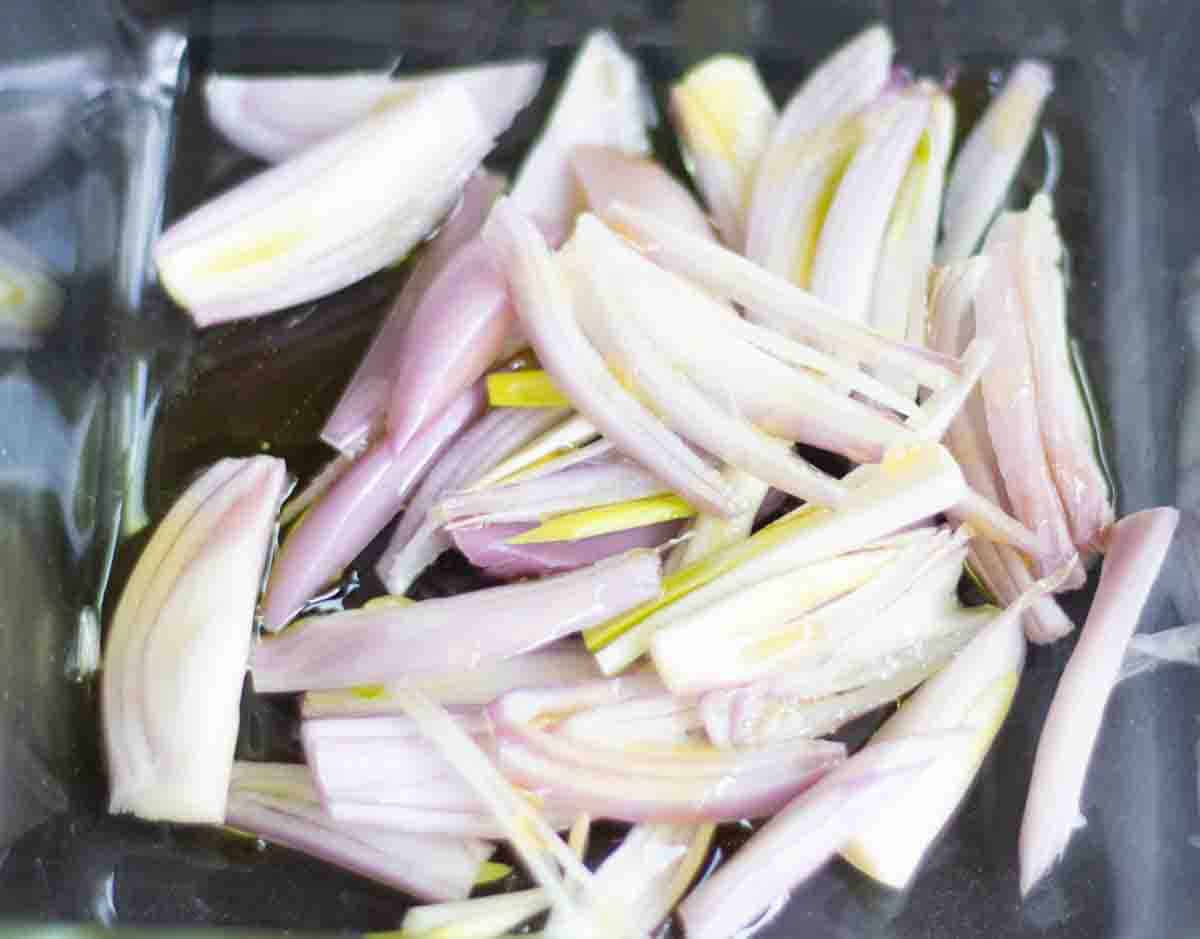 sliced shallots drizzled in oil in a baking dish