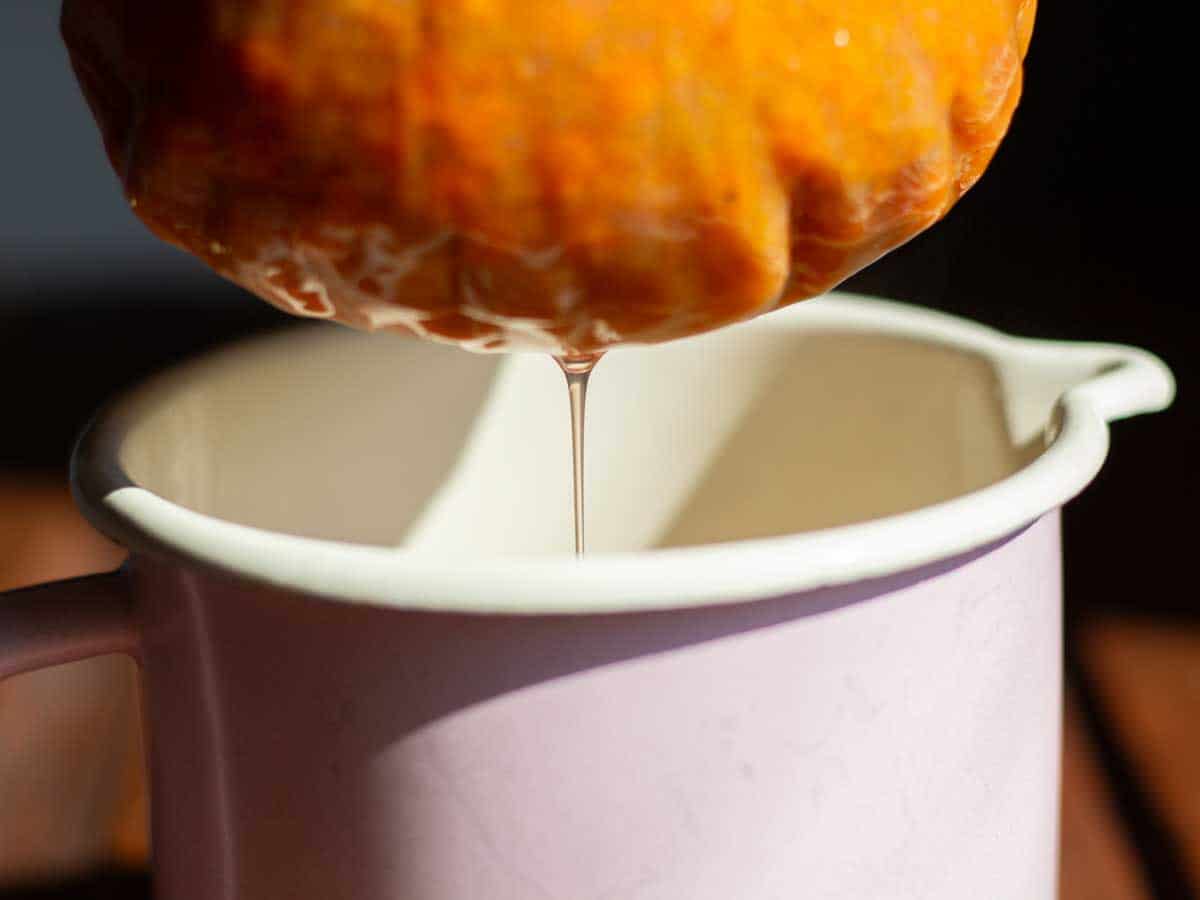 liquid draining from a muslin cloth filled with cooked rowan berries