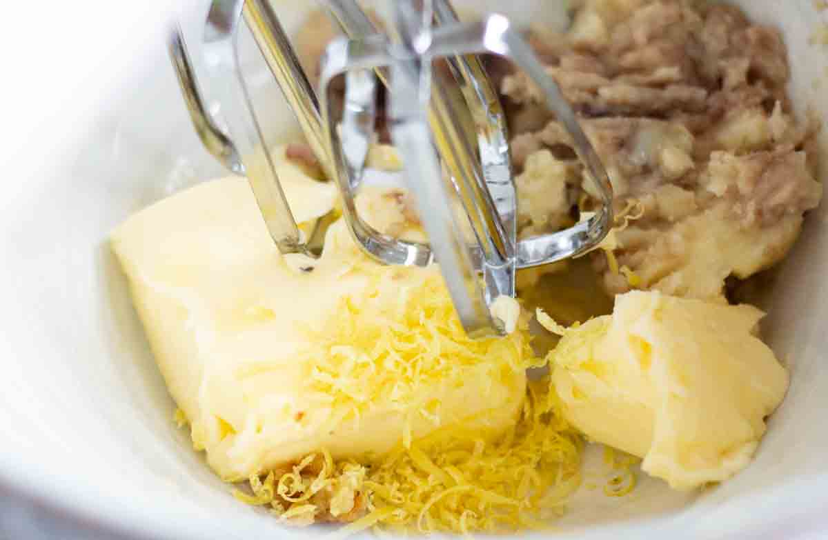 bone marrow butter ingredients in a large ceramic bowl with an electric whisk