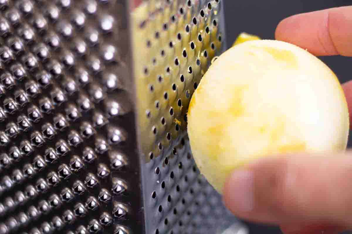 a hand zesting a lemon